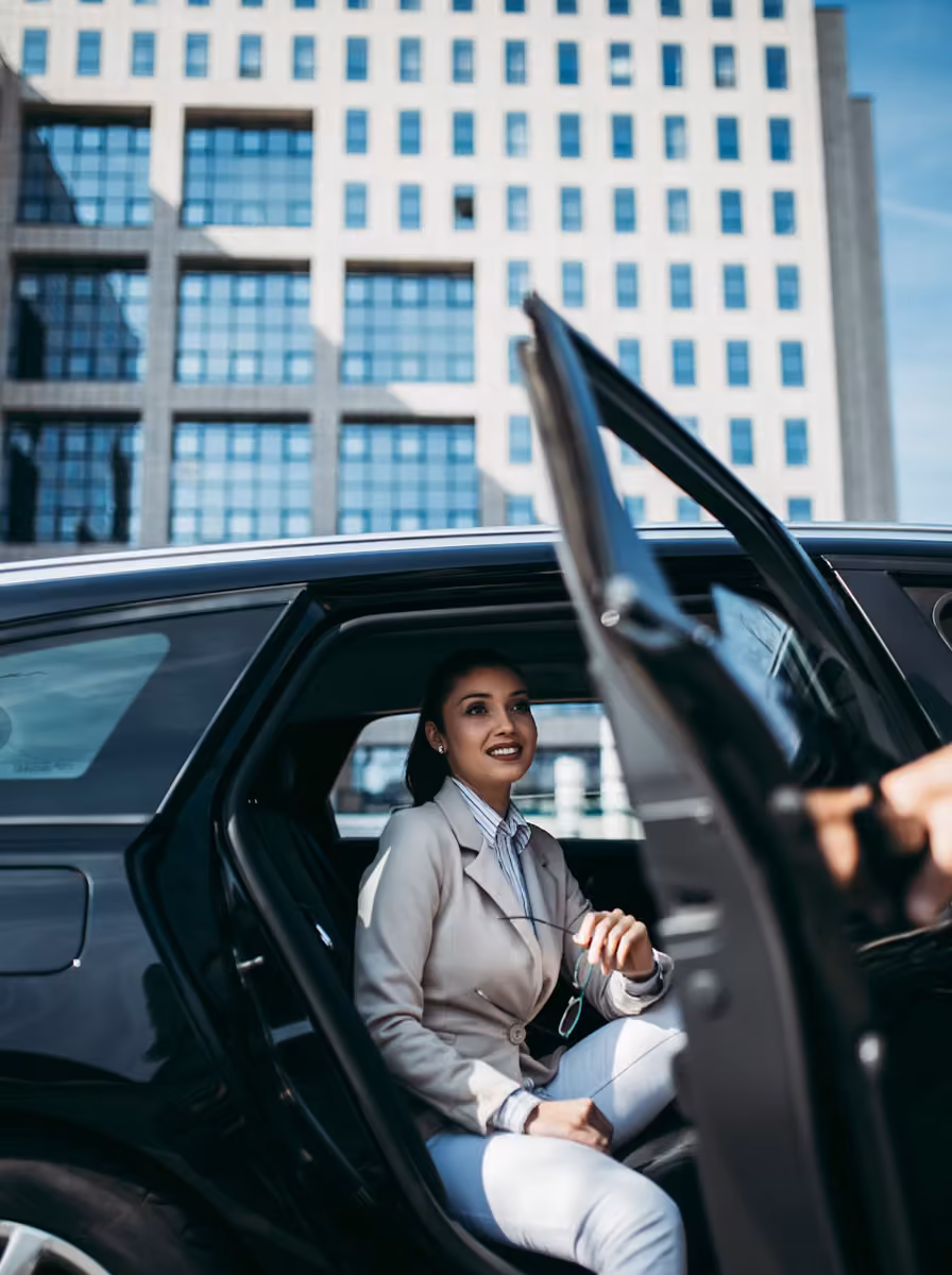 Lincoln limousine service client just reached her destination and the chauffeur is opening the door for her